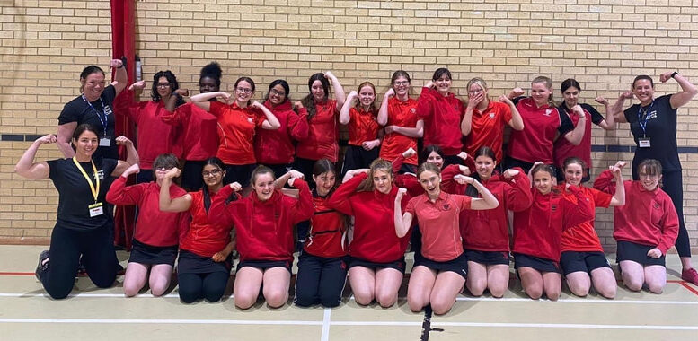 Two group photos of women and girls in red sports uniforms posing in a gym. Smiling and flexing their arms, the Strong Girl Squad Academy shows off their strength in front of a brick wall at Lincoln UTC.